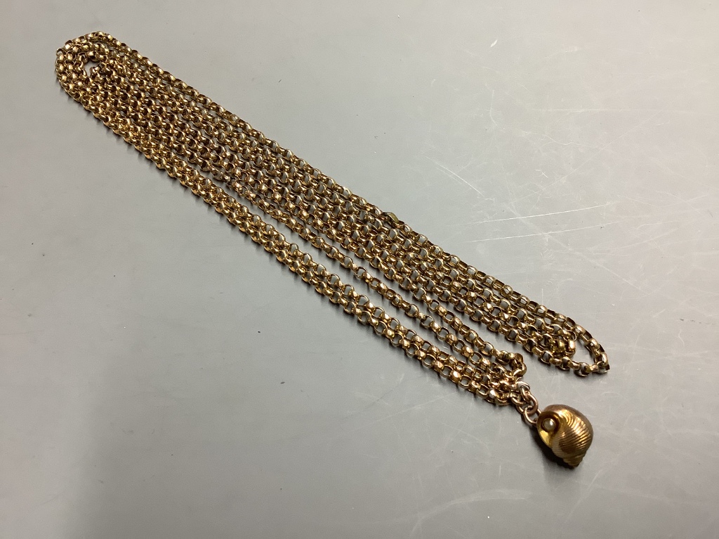 An early 20th century yellow metal (stamped 9c) guard chain, hung with a yellow metal and seed pearl set shell charm